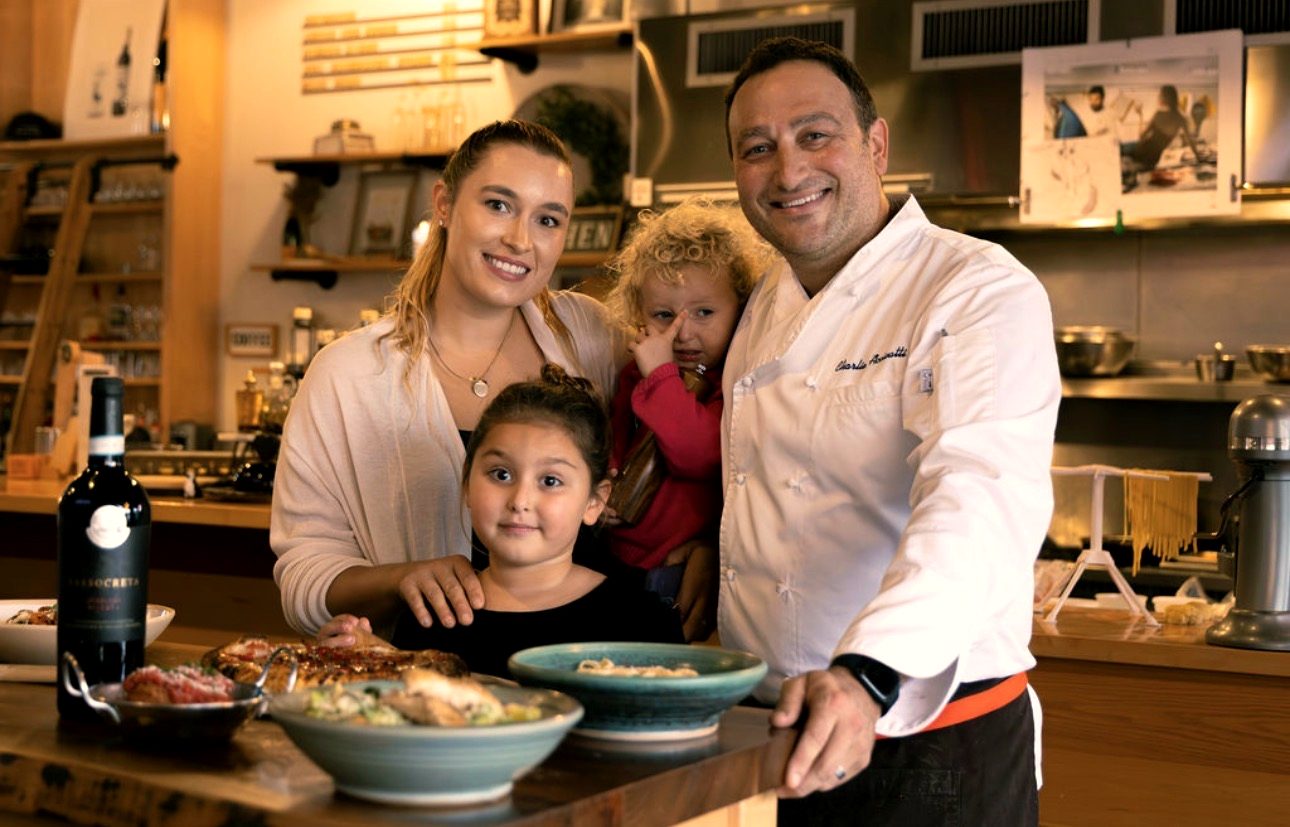 Charlie Accivatti in chef whites with family in his kitchen