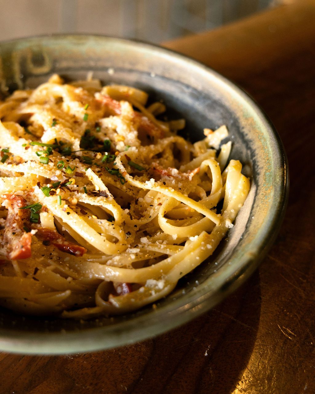 A bowl of linguine finished with herbs and pepper