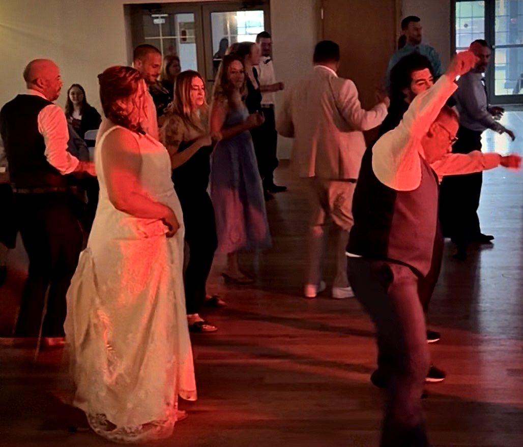 Bride and guests dancing on the floor in warm light