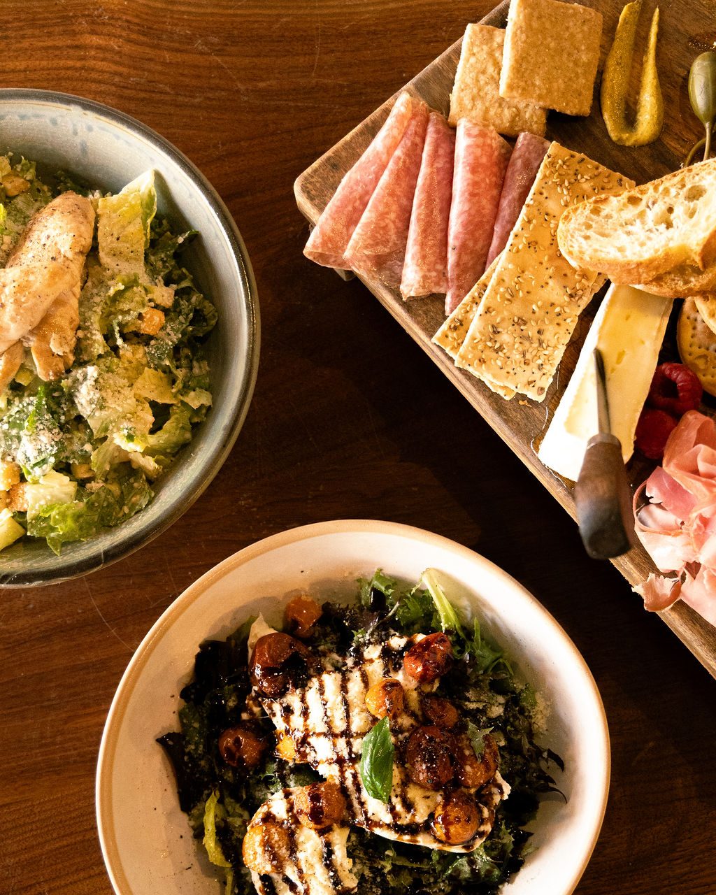 An overhead spread of salads and a charcuterie board